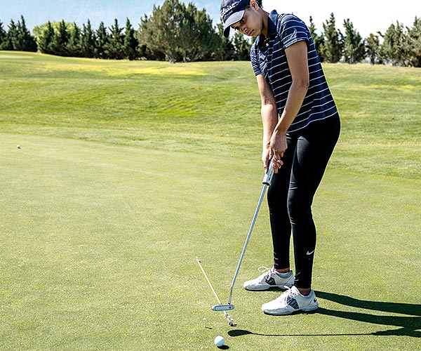 Young girl practicing on putting green Young girl practicing on putting green